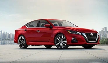 2023 Nissan Altima in red with city in background illustrating last year's 2022 model in Monken Nissan in Centralia IL